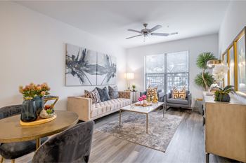 a living room with a ceiling fan and expansive windows at The Core apartments